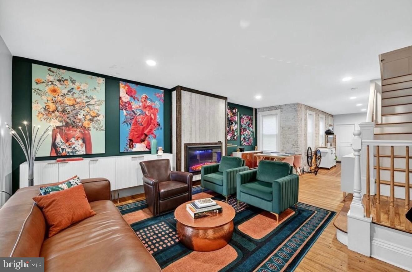 Open concept living room with original hardwood floors and exposed brick at 147 E Liberty St